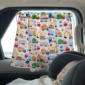 Car window sunshade with cartoon construction vehicles protecting a sleeping baby