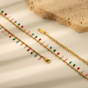 Bohemian 18K gold multilayer waist chain with colorful pendants on stone background