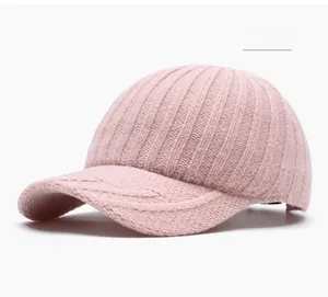 Macro detail of pink knit baseball cap showing thick vertical rib texture and brim