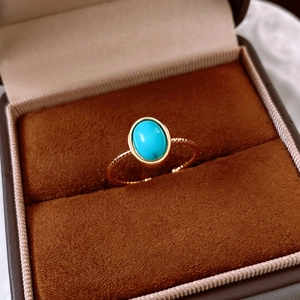 Detailed macro view of an 18k gold-plated ring with a blue turquoise oval stone