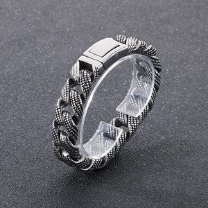 Macro detail of 15mm steel Cuban chain bracelet with textured snake scale pattern