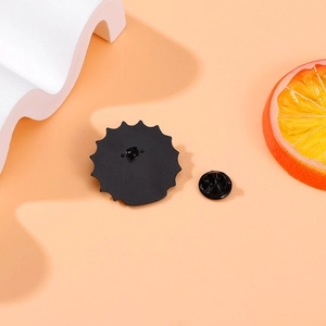 Cartoon eye badge with black gear shape metal back and rubber clutch on orange background