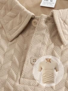 Gros plan sur la texture en tricot et l'étiquette du polo beige pour hommes