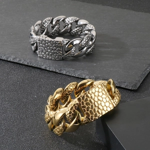 Detail of gold and silver cuban chain bracelets with pebble texture and hip hop style