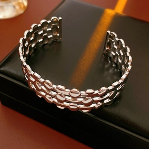 Detailed view of silver triple-layer hollow oval open bangle on a black jewelry display