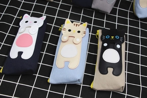 Detailed view of canvas cat pencil cases in blue and beige with cute leather patches