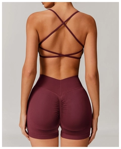 Detail view of high waist scrunch butt yoga shorts and cross back bra in deep burgundy