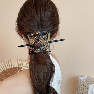 Detailed view of handmade floral embroidery hair clip and pin set on female model's hair
