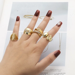 Close-up of gold ring set featuring zircon bow and teardrop designs on hand
