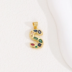Macro shot of letter S pendant with multi-colored cubic zirconia in gold plating