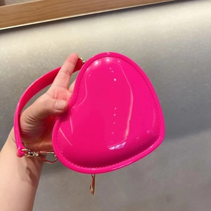 Close-up of pink heart-shaped glossy jelly bag featuring gold metal hardware details