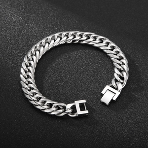 Detailed top view of silver Cuban chain bracelet with secure square clasp on black background