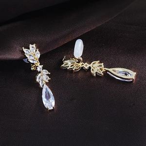 Detail of gold clip-on earrings with teardrop zircon and non-slip silicone pads