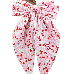 White bow hair clip with pink and red heart prints featuring long elegant streamers
