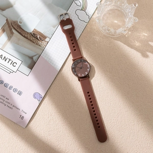 Close-up of a women's quartz watch with coffee silicone strap and artistic numeral dial