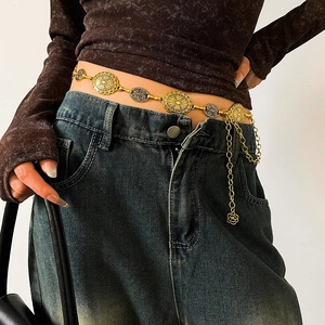 Detailed close-up of a vintage gold metal waist chain with sunburst relief and rose pendant