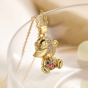 Macro view of gold-plated bear pendant with colorful zircon crystals and Cool engraving