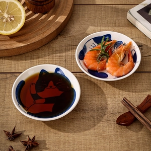 Japanese ceramic cat sauce dish and blue floral plate on wooden table setting