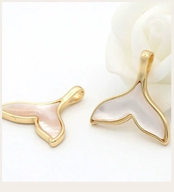 Close-up of whale tail shell pendants in gold plating for jewelry making and DIY projects