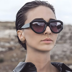 Close-up of stylish irregular oversized black sunglasses worn by a fashion model
