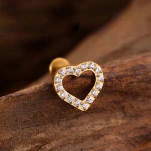 G23 titanium heart labret stud with inlaid crystals on a wooden background