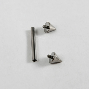 Detailed macro view of disassembled G23 titanium piercing bar with threaded cones