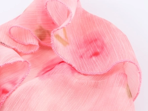 Nahaufnahme von rosa Blumen-Chiffonstoff mit eleganter Rüschenkante und weicher Textur
