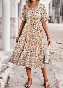 Close-up of floral print V-neck dress with ruffle short sleeves and tiered skirt details