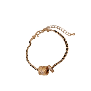 Gold cylinder flower pendant necklace with cubic zirconia on black braided cord