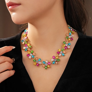Detailed view of a vintage gold floral necklace with colorful crystals on model neck