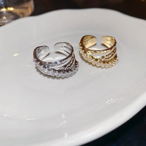 Close-up of three-layer crossover rings with pave zircon and hammered metal texture