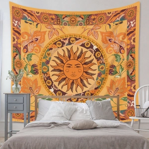 Detail of bohemian sun and floral tapestry hanging above a bed in a cozy bedroom