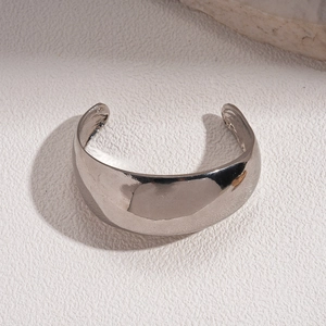 Macro detail of wide-band silver open cuff bracelet with high-polish mirror finish