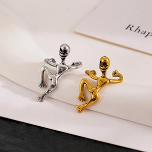 Detailed close-up of silver and gold gothic skeleton ear cuffs with a climbing pose design