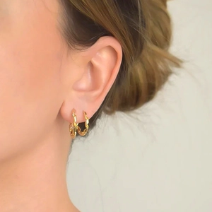 Close-up of a model wearing golden spiral twisted rope hoop earrings with S925 silver pins
