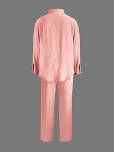 Detail of pink long sleeve shirt and trousers set featuring textured crinkle fabric