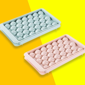 Close-up of pink and blue round ice ball molds with 33 holes on a vibrant background