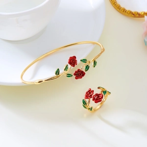 Detailed view of golden flower bracelet and ring set with red rose enamel work