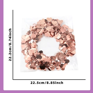 Close-up of rose gold heart tinsel garland decoration measuring 22.5cm by 22.2cm