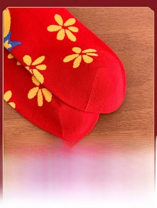 Close-up of reinforced toe detail on red cotton socks with yellow floral patterns