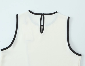 Detail of white crepe top showing back teardrop opening and black contrast trim