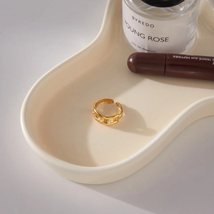 Détail d'une bague en acier inoxydable plaqué or 18K ornée de trois zircons clairs