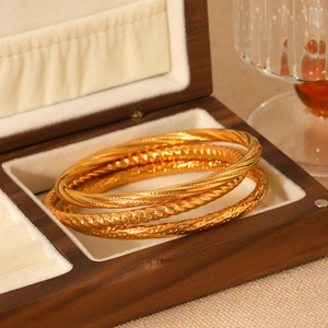 Three-piece gold stainless steel bangles with twisted, diagonal, and hammered textures