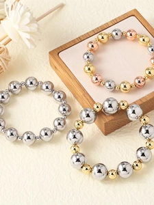 Detailed view of beaded bracelets in gold, silver and rose gold on a jewelry stand