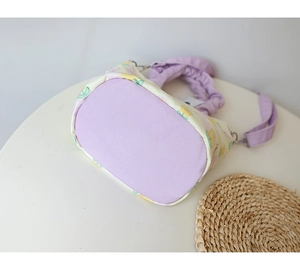 Macro shot of the reinforced purple base and lemon pattern canvas of the bucket bag