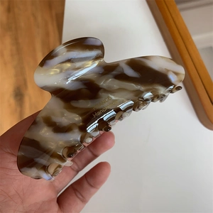 Detail showing the large tortoiseshell hair claw with gold France Handmade lettering