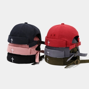 Detail of diverse docker hats with cross embroidery and adjustable metal buckles