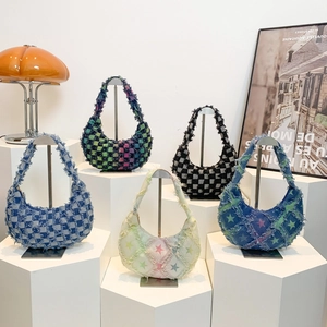 Collection of denim underarm bags in plaid and star patterns on studio pedestals