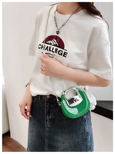 Close-up of a green mini glossy chain bag featuring a sleek silver shoulder strap