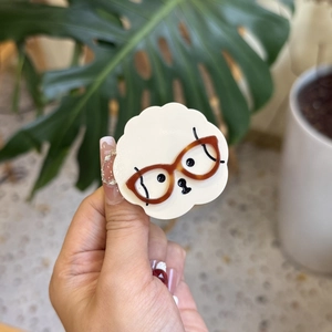 Cute acetate dog hair claw clip with brown tortoiseshell glasses in a cream finish